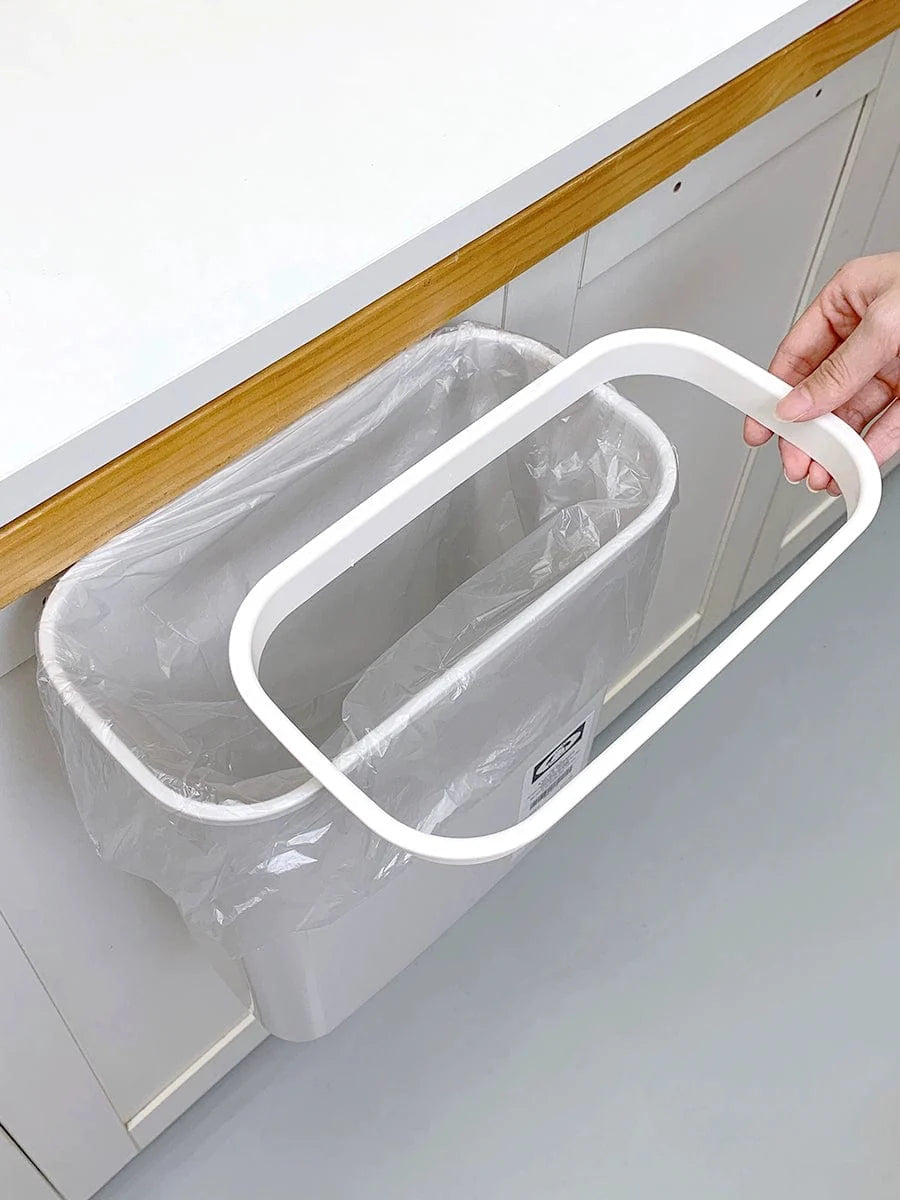 Wall-mounted Donha 4L plastic kitchen trash can hanging on a cabinet door for convenient waste disposal.