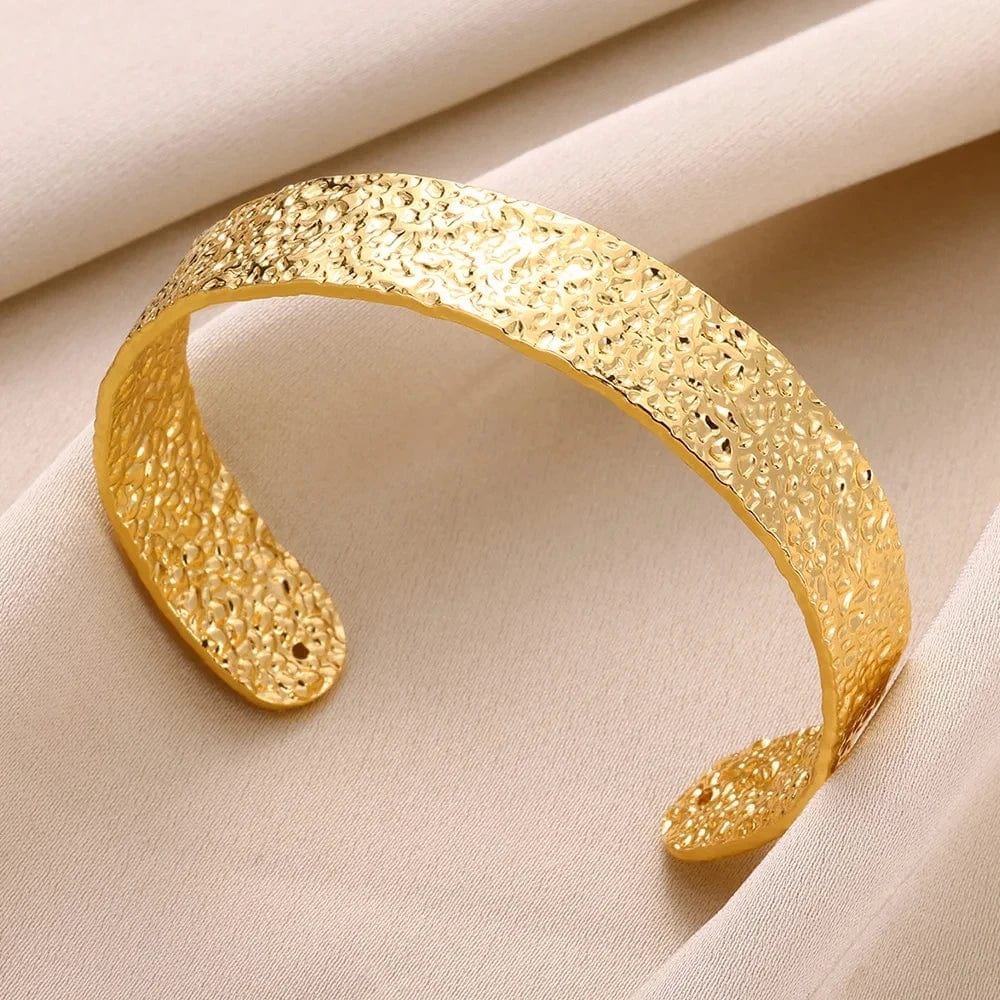 Gold stainless steel cuff bracelet with bump pattern for women, featuring an open design and elegant hand ornament style.