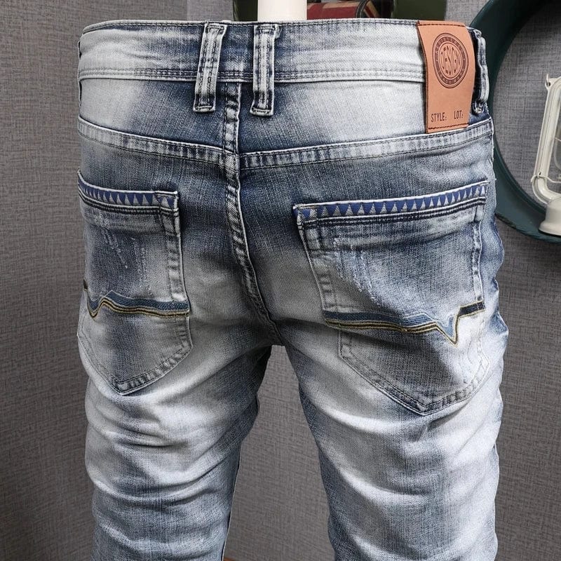 Light blue slim fit ripped denim jeans for men by Showlu Fashion, featuring a retro style and stretch fabric for casual wear.