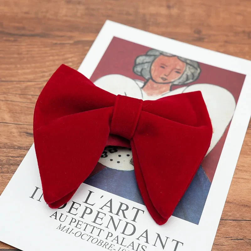 Black velvet oversized bow tie and pocket square set for tuxedos, featuring red, navy, white, and green accents.