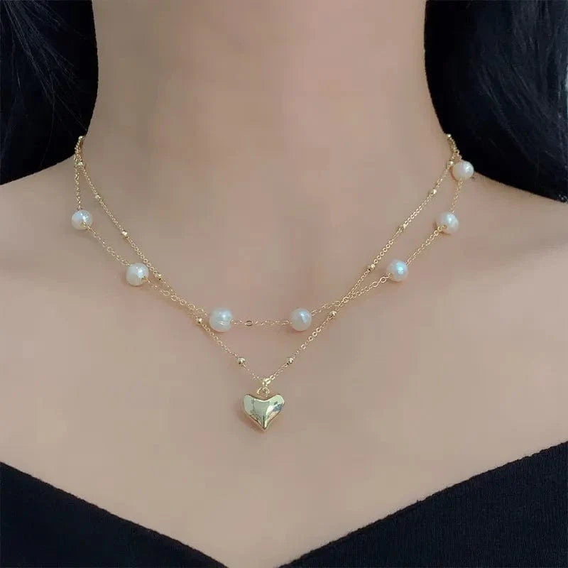 Elegant double-layer pearl love pendant necklace by Showlu Fashion, featuring copper jewelry design for women’s wedding and party wear.