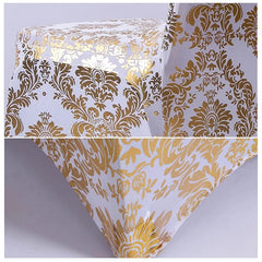 A white chair cover featuring a metallic gold damask print pattern.