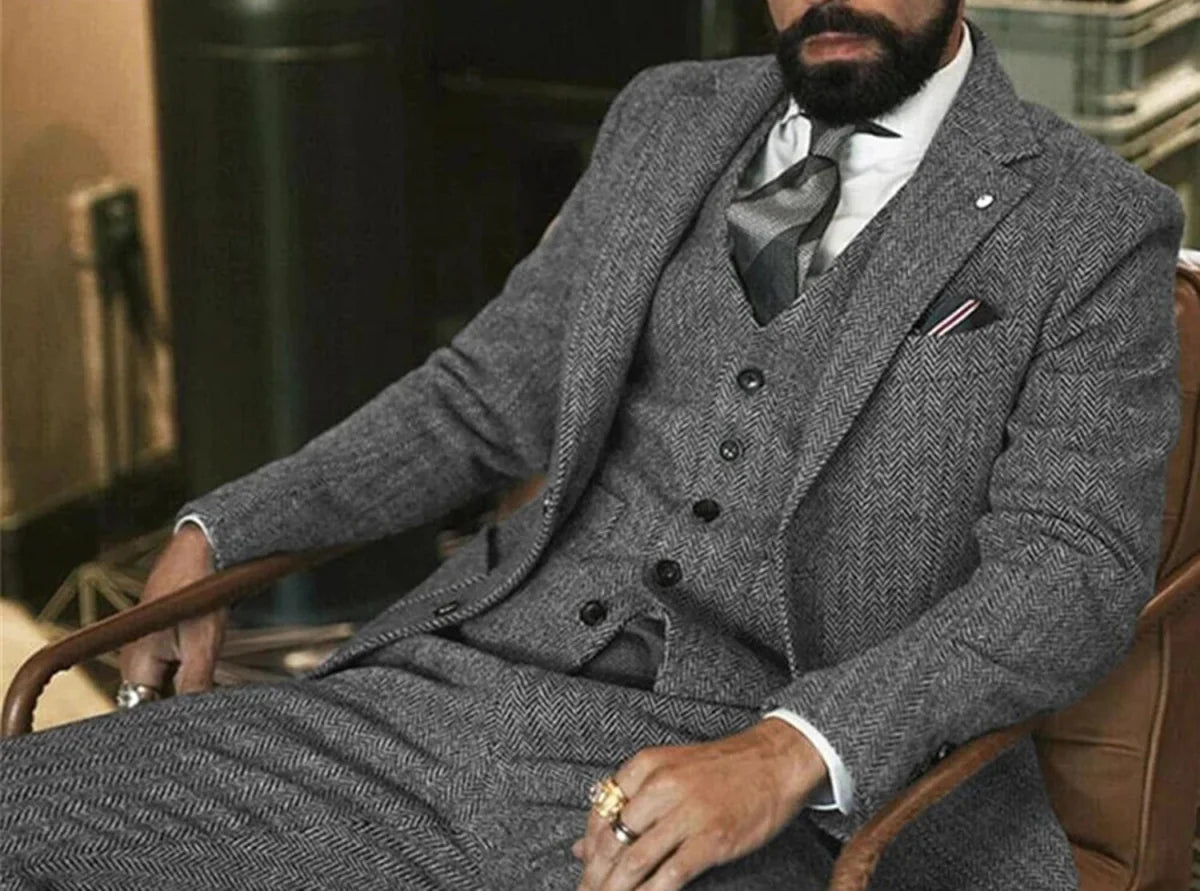 Gray herringbone wool tweed 3-piece men's winter suit with slim fit, jacket, vest, and pants, suitable for formal or wedding occasions.