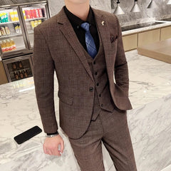 A man wears a brown plaid three-piece suit with a black shirt and blue tie.