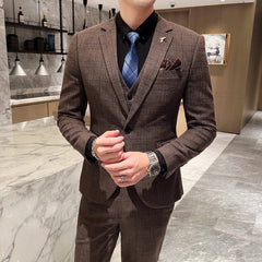 A man wears a brown plaid three-piece suit with a black shirt and blue patterned tie.