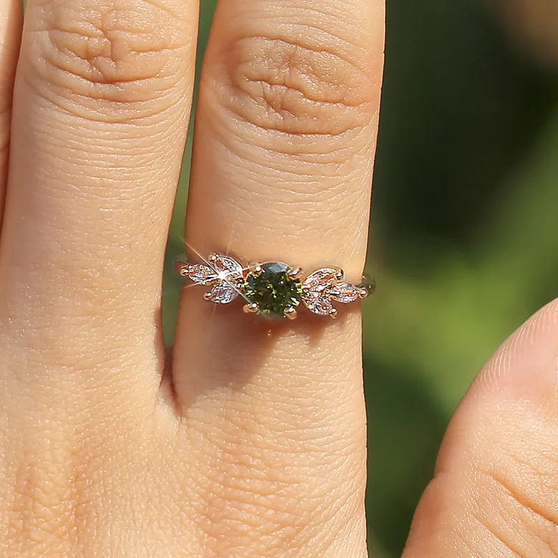 Elegant Huitan women's wedding ring with olive green zircon, gold leaf band, delicate design, perfect for special occasions.