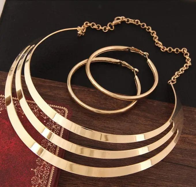 Gold torques necklace and round earrings set by KMVEXO, stylish women's jewelry for parties and special occasions.