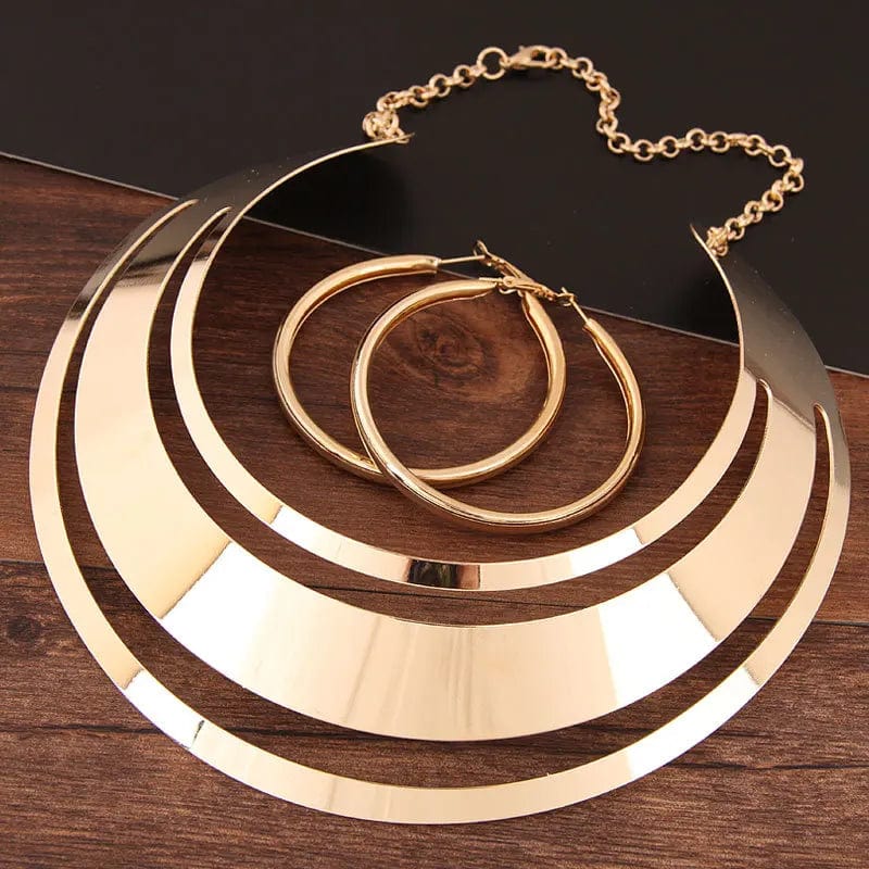 Gold torque necklace and round earrings set by KMVEXO featuring stylish women's jewelry for parties and special occasions.