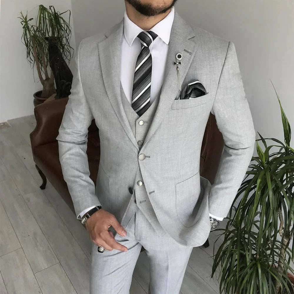 Light gray 3-piece men's suit with notch lapel, slim fit, formal tuxedo style featuring jacket, vest, and pants, perfect for weddings.