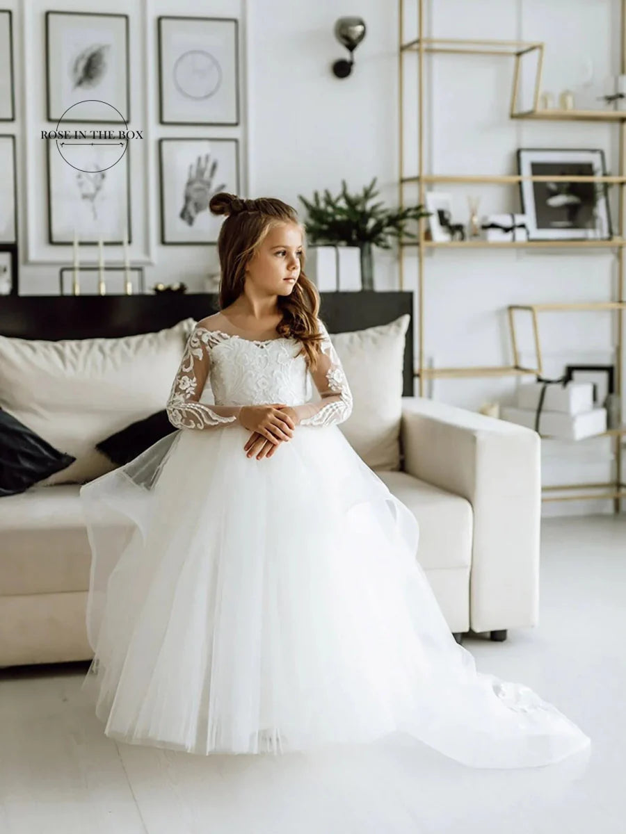 Long-sleeve lace flower girl dress in white with a ball gown style, featuring intricate lace details for special occasions.