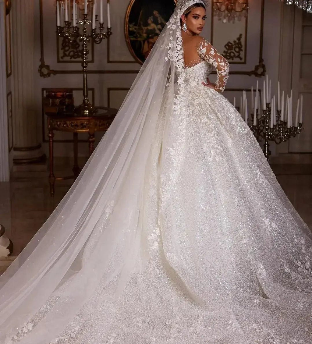 Vinca Sunny Lace Ball Gown Wedding Dress by Showlu Fashion with long sleeves, tulle fabric, sequins, beads, and sheer neckline.