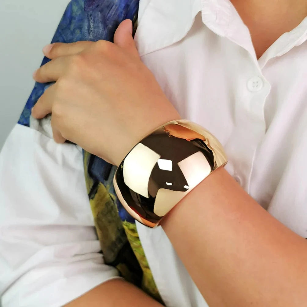 Wide gold alloy cuff bangle for women, shiny statement punk bracelet with bold, metallic design and modern jewelry style.