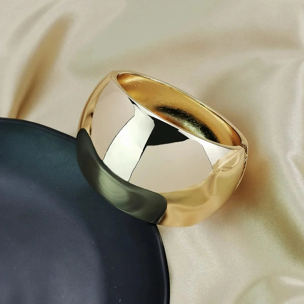 Wide gold alloy cuff bangle for women, bold statement jewelry with shiny surface, stylish punk-inspired bracelet from Showlu Fashion.