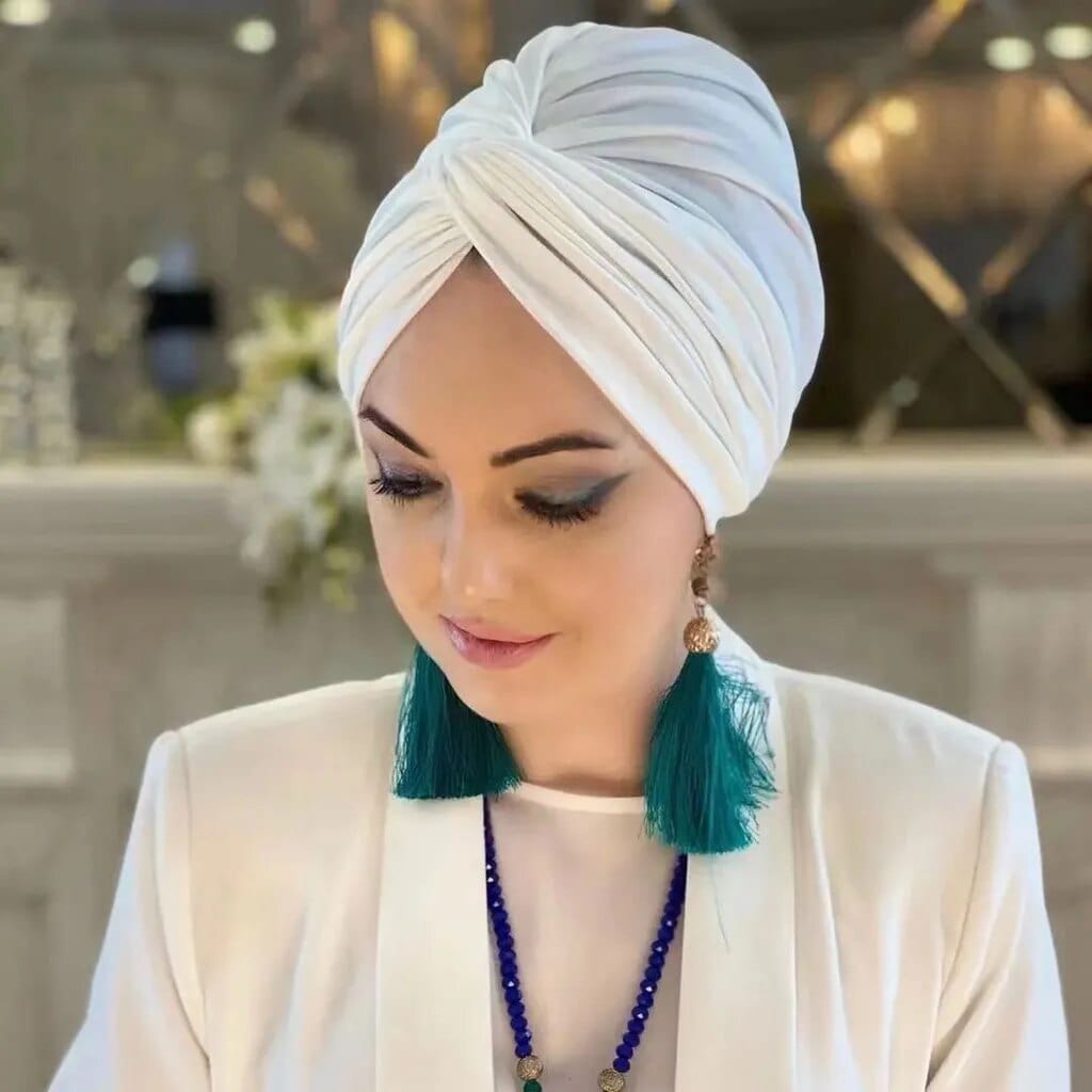 Pearl white Motive Force modal hijab undercap, slim fit jersey turban for Muslim women, shown with abayas and headscarves.