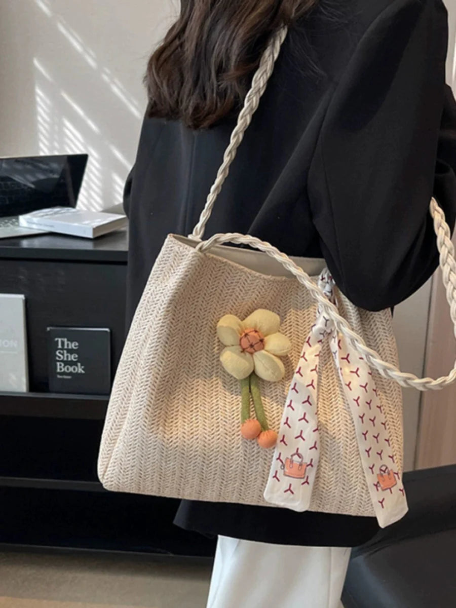 Large woven straw bucket bag with shoulder strap, spacious summer tote for women, featuring a stylish, natural straw design.
