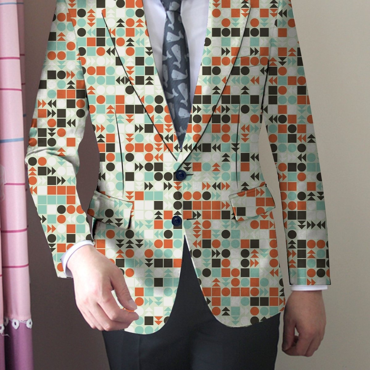Men's slim fit blazer with vibrant geometric print, polyester fabric, buttoned lapels, in orange, green, and blue tones.