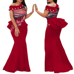 A red floor-length mermaid dress with an off-shoulder neckline, pearl accents, and floral applique.