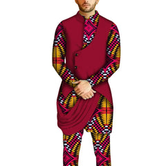 A man wears a traditional African two-piece set featuring a patterned shirt and matching pants.