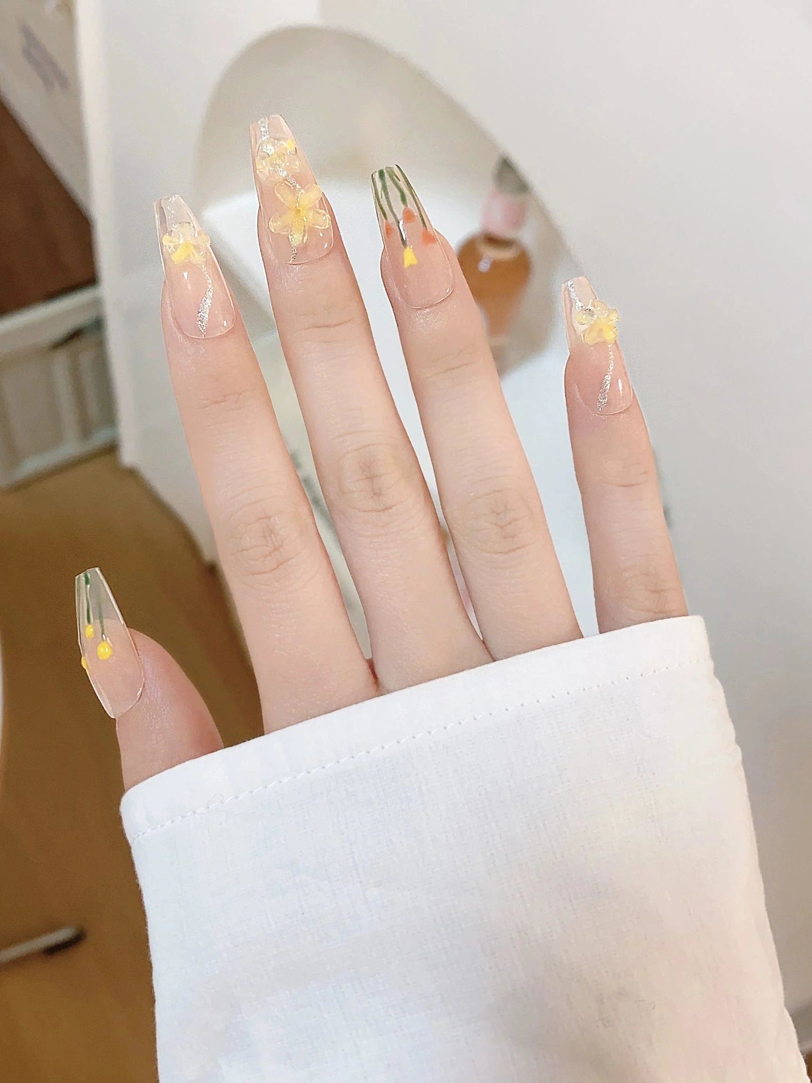 Xiaonan Classmate Aurora Camellia press-on nails in a gentle blush design, worn on natural nails with floral accents.