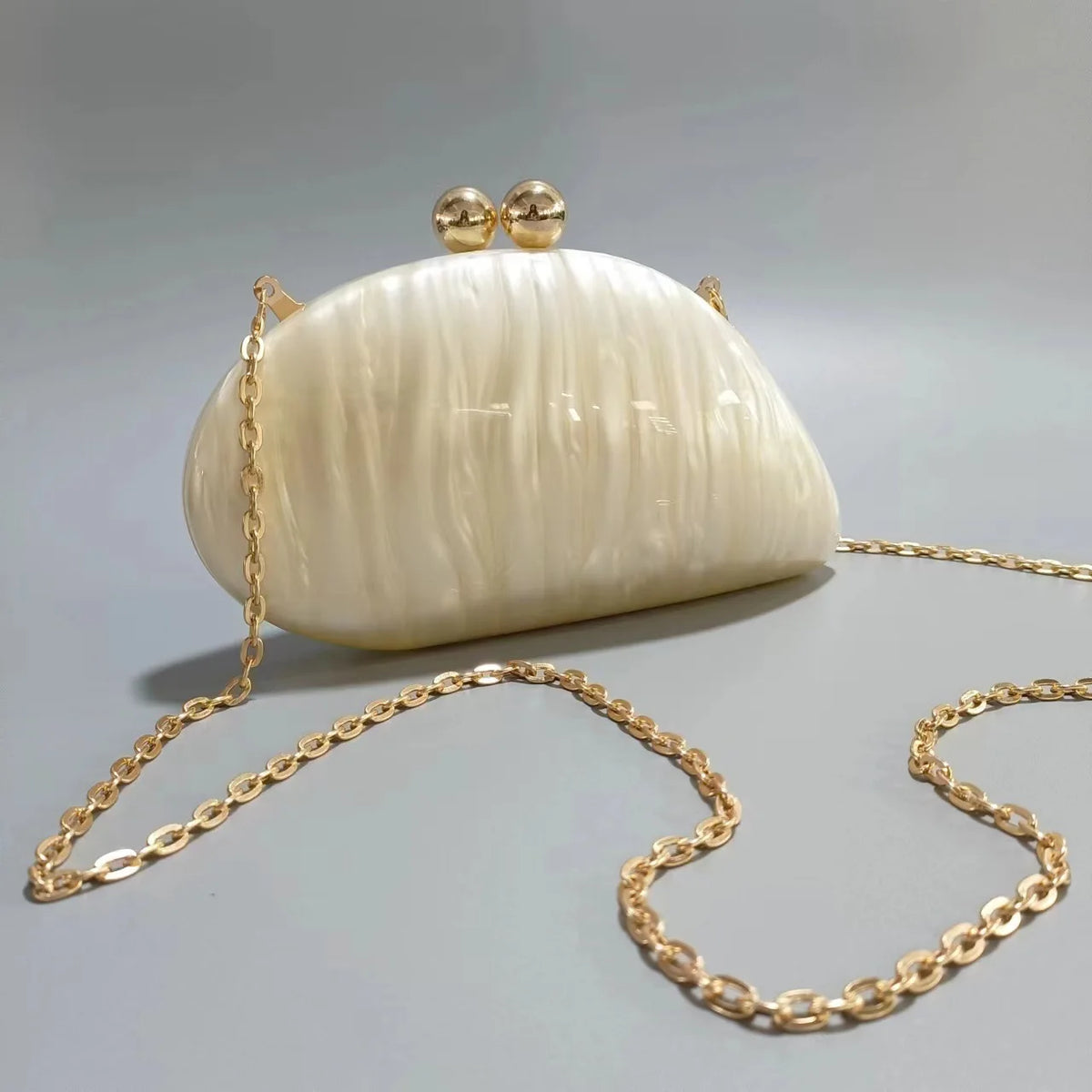 Blue acrylic shell-shaped clutch bag for women, designer evening purse with pearl accents, ideal for parties and special occasions.