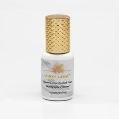 A bottle of Pinky Leem banana scented eyelash extension glue with a gold textured cap.