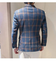 A man wears a blue and orange plaid single-breasted blazer with a notched lapel.