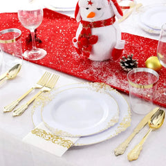 A place setting featuring white plates with gold embossed rims, gold cutlery, and clear cups.
