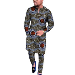 A man wears a traditional African two-piece set featuring a long-sleeved V-neck shirt and trousers.