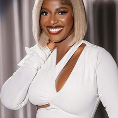 A woman wears a white long-sleeve mini dress featuring a V-neckline and a side cut-out detail.