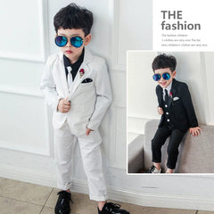 A young boy wears a three-piece suit with a blazer, vest, and trousers in white or black.
