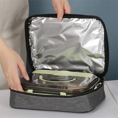 A person opens a gray square insulated lunch bag containing a bento box.