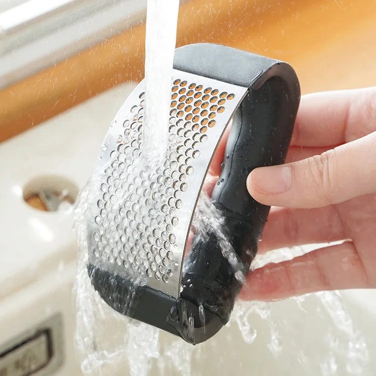 Showlu Fashion Store stainless steel garlic press and mincer, a manual kitchen crusher tool for garlic and vegetable preparation.