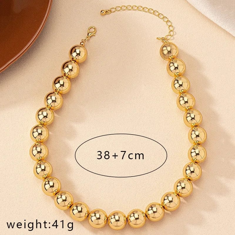 Gold ball beads chain necklace featuring a steampunk gothic style, worn as a choker for women and men, stylish jewelry accessory.