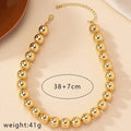 Gold ball beads chain necklace featuring a steampunk gothic style, worn as a choker for women and men, stylish jewelry accessory.