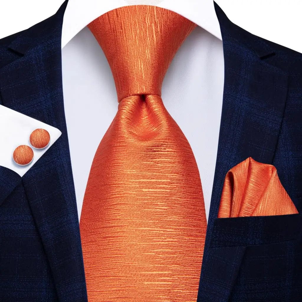 Orange silk necktie set with matching pocket square and cufflinks, featuring bold stripes for men's formal or wedding attire.