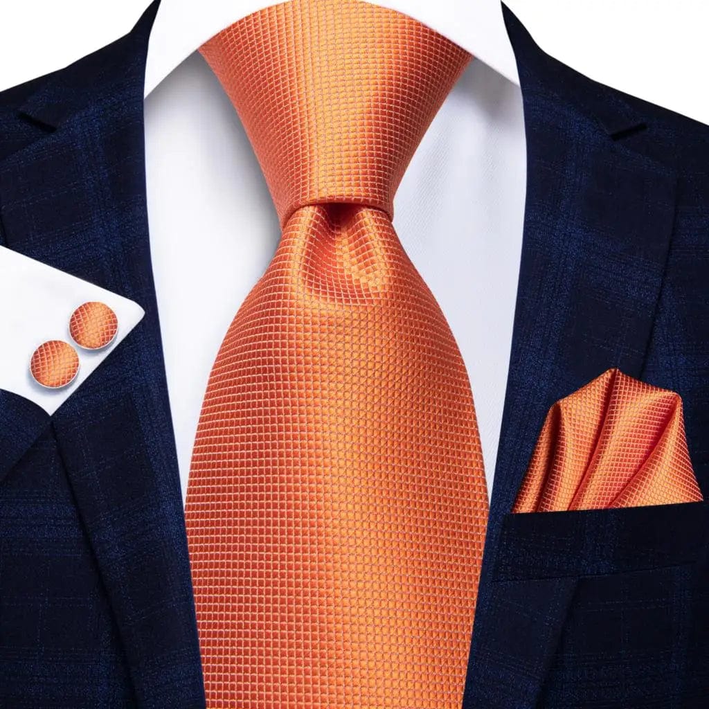 Orange silk necktie set with striped design, matching pocket square and cufflinks, for men's formal or wedding attire.