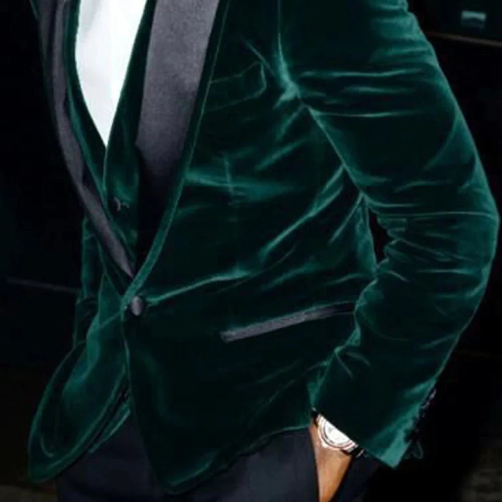 Dark green velvet men's 3-piece slim fit tuxedo with black peaked lapel, shown on a groom for wedding or formal event.