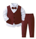 Boy in navy blue tuxedo suit with vest, bowtie, white shirt, and matching pants for wedding or formal occasion.