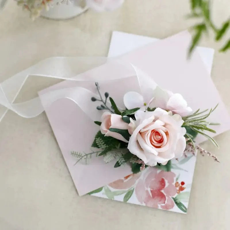 Artificial white silk rose boutonniere and wrist corsage with red rose accents, perfect for wedding bridesmaids and guests.
