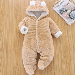 A tan, long-sleeved, hooded baby romper with bear ears and white trim on a wooden background.